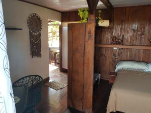 - une chambre avec un lit et un mur en bois dans l'établissement Cabana Luna, à Jicaral