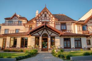 a large house with a tiled roof at Hotel L' Hirondelle in La Falda