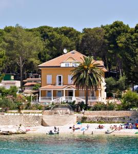 ein Haus am Strand mit Leuten am Strand in der Unterkunft Kredo B&B in Mali Lošinj