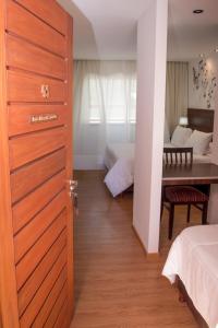 Habitación con puerta y dormitorio con mesa. en Hostal L' Hirondelle en La Falda