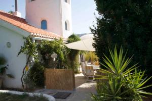 un edificio con ombrellone e tavolo e sedie di Melegis 4-Bed Villa Sleeps 7 Pool & Garden a Melegis