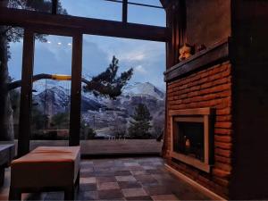 a living room with a fireplace with a mountain view at Elia Loft in Kazbegi