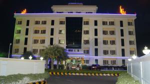 a large white building with flames on it at night at Hotel MGM Grand in Srikalahasti