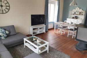 a living room with a couch and a tv and a table at maison 2 chambres spa Crozon proximité plages in Telgruc-sur-Mer +45 photos