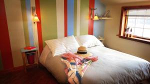 una camera con un letto con un cappello sopra di Auberge Café Acadien a Bonaventure