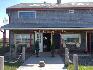 a house with a porch with flags on it at Café Acadien in Bonaventure