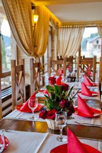 a table with red napkins and red flowers on it at Pensiunea Inima Bucovinei in Frasin