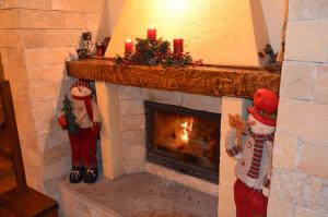 a fireplace with christmas decorations and candles on it at Pensiunea Inima Bucovinei in Frasin