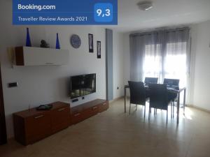 sala de estar con mesa de comedor y TV en Casa Mila en Puerto del Rosario