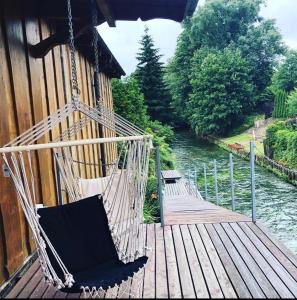 a hammock hanging from a building next to a river at Pokoje agroturystyczne U Hani in Ostrzyce