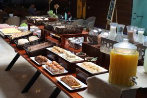 a table filled with different types of pastries and orange juice at Howard Johnson La Cañada Hotel & Suites in Cordoba
