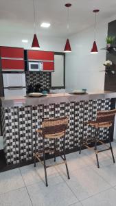 a kitchen with two chairs and a counter top at Lindo Apartamento Varanda no centro de Paulo Afonso in Paulo Afonso