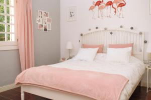 1 dormitorio con 1 cama con sábanas rosas y blancas en Blonski Guadalmar en Málaga