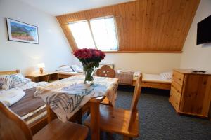 a room with a table with a vase of flowers on it at Willa Świdrówka 2 in Poronin