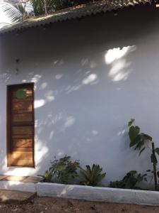 Casa blanca con puerta y ventana en Chale Das Flores, en Trindade