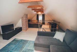 a living room with a couch and a tv at Mazais Līvkalns in Sigulda