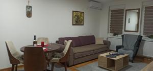 uma sala de estar com um sofá e uma mesa em Apartman N&N em Vrnjačka Banja