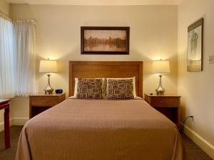 Un dormitorio con una cama grande con dos lámparas. en Oasis Guest House, en Boston
