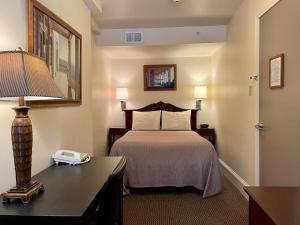 Habitación de hotel con cama y escritorio con lámpara. en Oasis Guest House en Boston