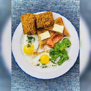 un piatto di alimenti con uova, pane tostato e broccoli di НОЙ Отель Кропоткин Пожарная a Kropotkin