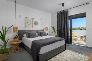 a bedroom with a large bed and a balcony at Seawater Villa in Lachania