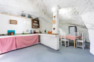 Cette chambre blanche dispose d'une table et de chaises. dans l'établissement Eco Holidays House Raíces, à Fasnia