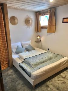 ein Schlafzimmer mit einem Bett in einem Zimmer mit einem Fenster in der Unterkunft Chalet Cyclamens- 65m2 plein centre des Carroz - WIFI & parking! in Les Carroz d'Araches