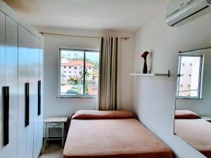 a small room with two beds and a window at Apartamento Modus Vivendi in Ilhéus