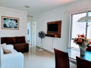 a living room with a table and a couch and a television at Apartamento Modus Vivendi in Ilhéus