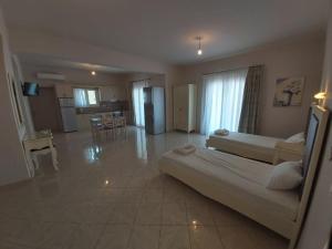 a large bedroom with a large bed and a kitchen at Konstantinos Apartments in Ammoudia