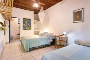 1 dormitorio con 2 camas y mesa en Residence Picinguaba, en Picinguaba