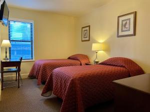 a hotel room with two beds and a window at Oasis Guest House in Boston