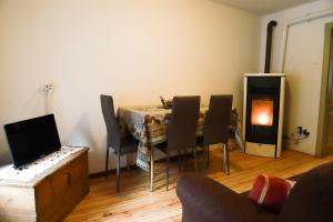 - un salon avec une table, des chaises et une cheminée dans l'établissement COL DE RIF Appartamento Storico nelle Dolomiti, à Falcade