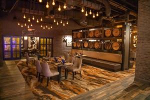 uma sala de jantar com mesa, cadeiras e barris de vinho em Oak Grove Racing Gaming Hotel em Oak Grove