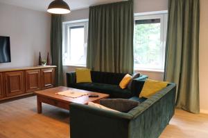 a living room with a couch and a coffee table at Dom Pod Sosnami in Mielno