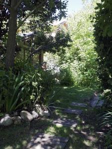 einen Garten mit einem Weg zum Haus in der Unterkunft Cabaña entre Arboles in San Carlos de Bariloche