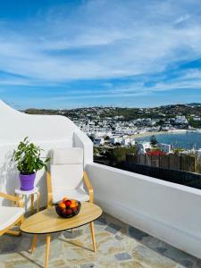 a balcony with a bowl of fruit and a table and chairs at Modern Cycladic Sea View House in Ornos