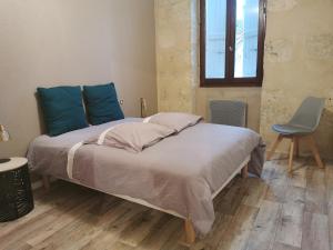 Un dormitorio con una cama con almohadas azules y una silla en Appartement de charme, au cœur d'Auch, 4 pers, en Auch