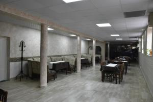 un comedor con mesas, sillas y columnas en Suhin Dol Hotel, en Belimel