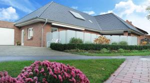 a house with a fence and flowers in front of it at Dümmernest in Hüde