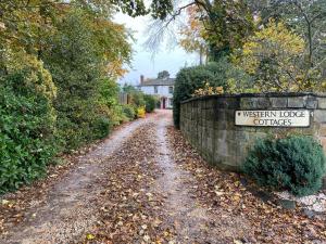 a dirt road with a sign that reads museum lodge quarters at Cosy Cottage in Durham City in Durham