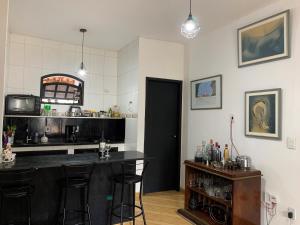 una cocina con barra y un bar con taburetes en Hostel Suite Home en Saquarema