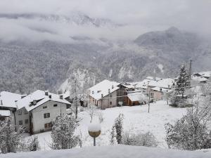 un pueblo cubierto de nieve con montañas en el fondo en Appartamento In Montagna, en Venas