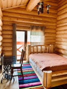 1 dormitorio con 1 cama en una cabaña de madera en Коло Хорса, en Slavske