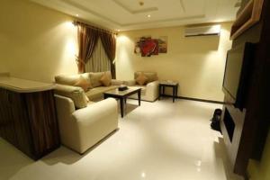 a living room with a couch and a tv at شقق توليب الروضه للشقق المخدومة in Riyadh