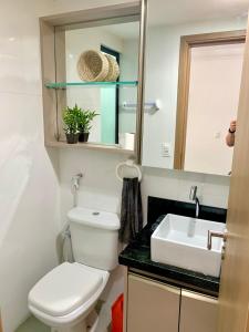 uma casa de banho com um WC branco e um lavatório. em Mauí beach resort em Tamandaré