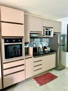 une cuisine avec des armoires blanches et des appareils en acier inoxydable dans l'établissement Mauí beach resort, à Tamandaré