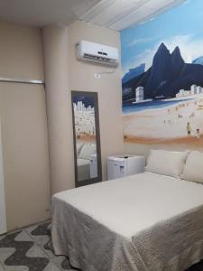 een slaapkamer met een bed en een schilderij van een strand bij Hotel Nacional in Sobral