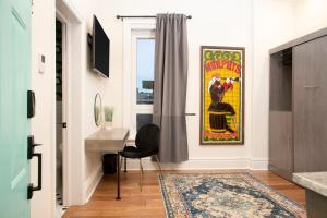 a living room with a desk and a painting on the wall at The Juniper Inn in St. Catharines