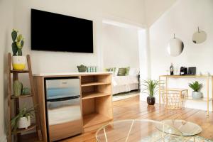 sala de estar con TV de pantalla plana en la pared en The Juniper Inn en Saint Catharines